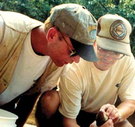 Photograph of two USGS scientists in the field examining a fish.